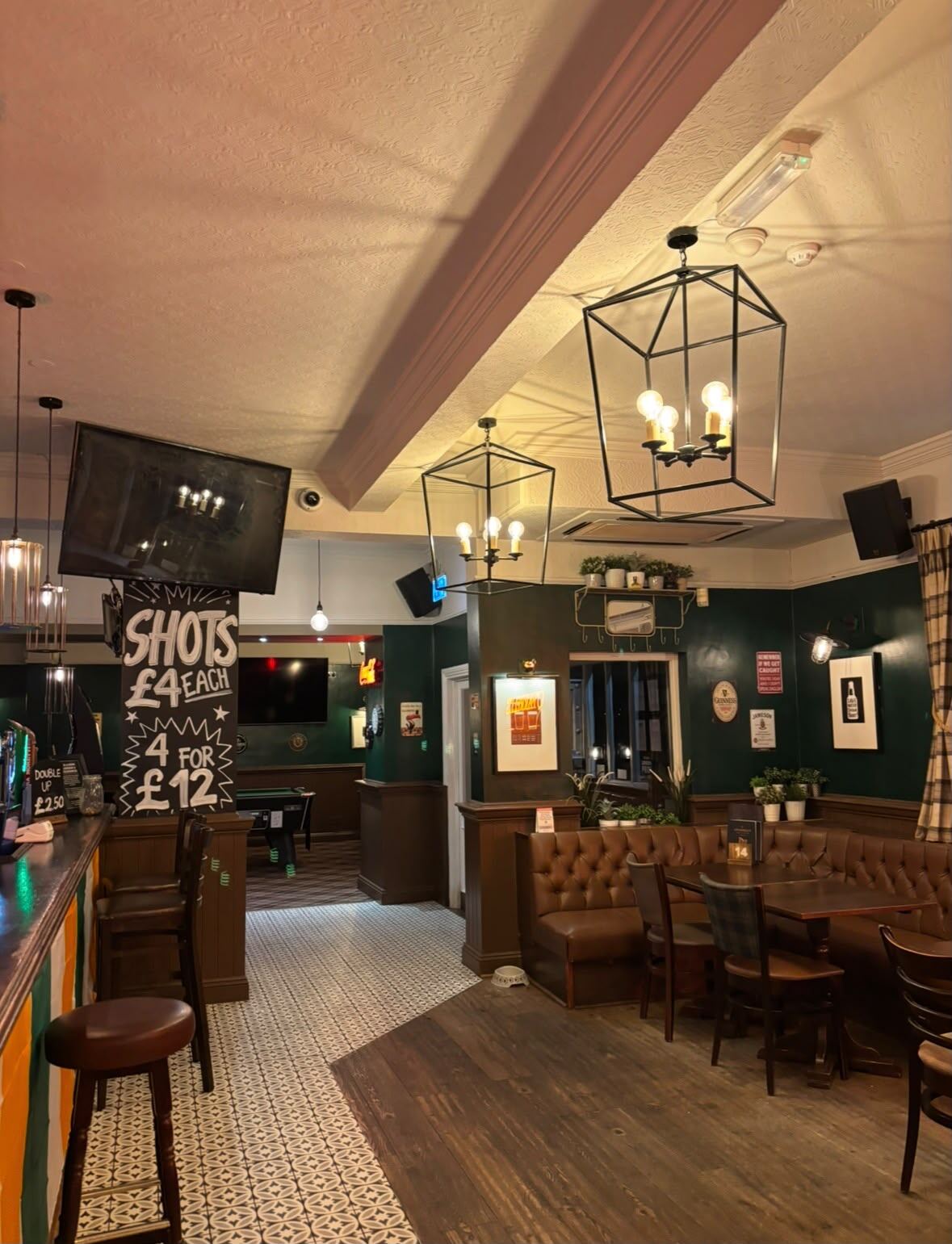 Inside O'Farrell's: cage lanterns over the bar, the shots deal board on the wall and tan leather seating below